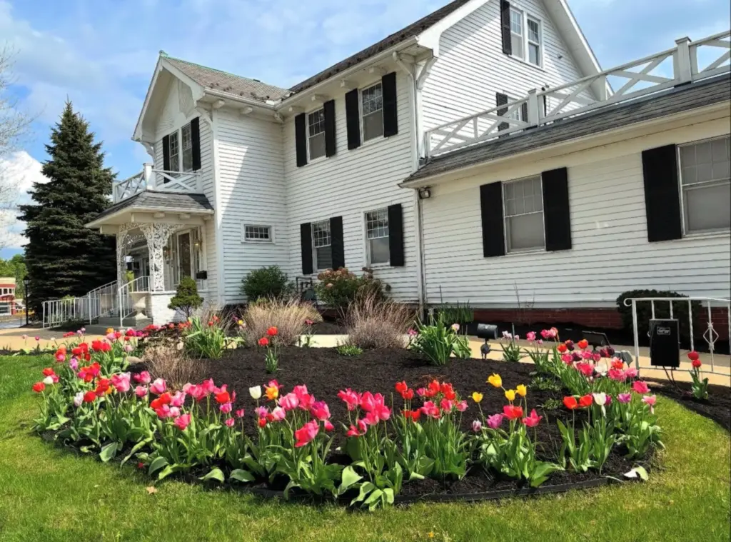 Spring tulip flower bed with fresh mulch landscaping in front of a white home in Northeast Ohio