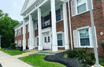 Commercial landscaping with fresh mulch beds and trimmed greenery in front of a brick office building in Northeast Ohio