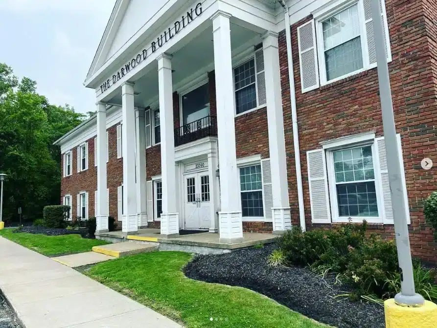 Commercial landscaping with fresh mulch beds and trimmed greenery in front of a brick office building in Northeast Ohio