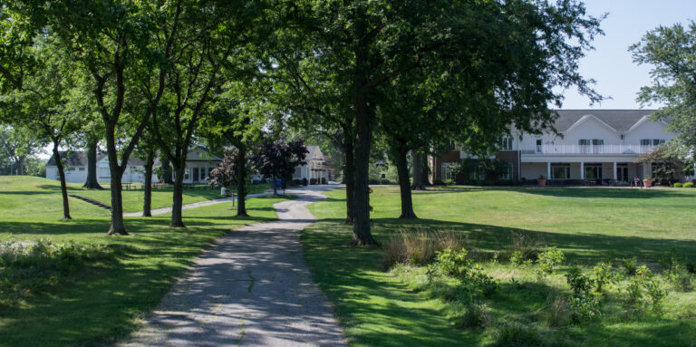 Acacia Reservation clubhouse in Lyndhurst, glimpsed through dense green tree canopy